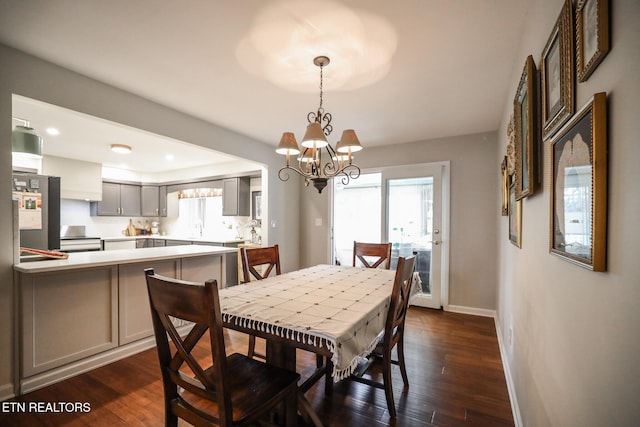 dining room featuring dark wood-style floors, plenty of natural light, and baseboards