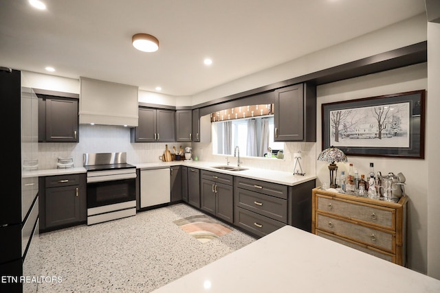 kitchen featuring tasteful backsplash, electric range, white dishwasher, light countertops, and a sink