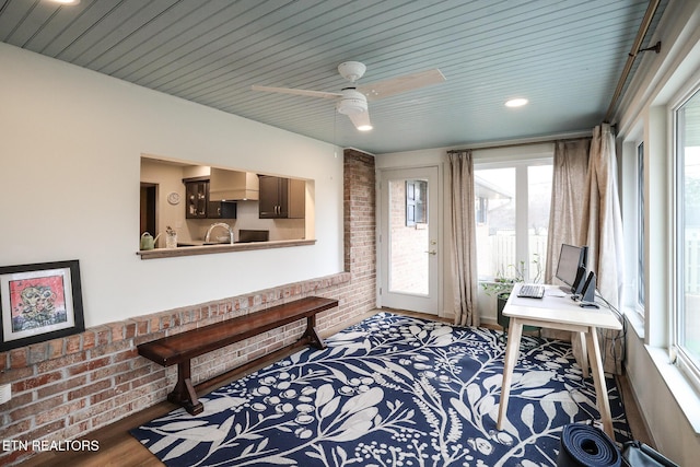 interior space featuring brick wall and wood finished floors