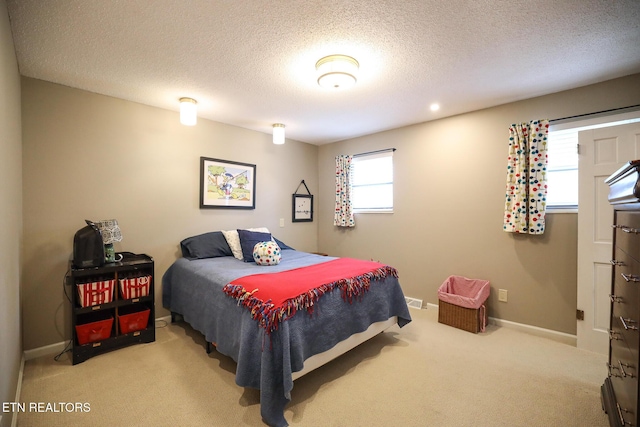 bedroom with carpet, a textured ceiling, and baseboards