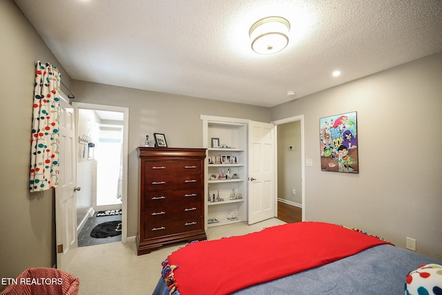 bedroom with a textured ceiling, carpet flooring, and baseboards