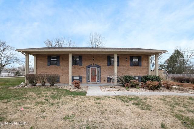 bi-level home featuring brick siding and a front yard