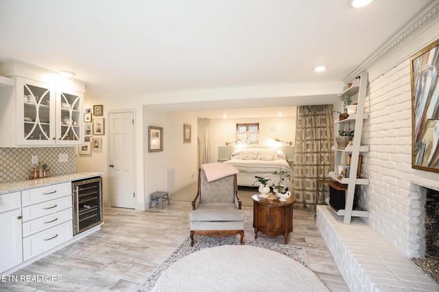 living area with beverage cooler, visible vents, a dry bar, and light wood finished floors