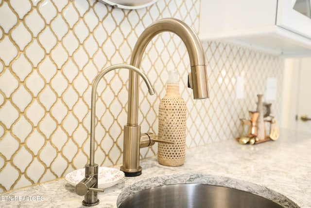 interior details with light stone counters and a sink