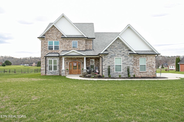 craftsman inspired home featuring french doors, a shingled roof, a front yard, and fence