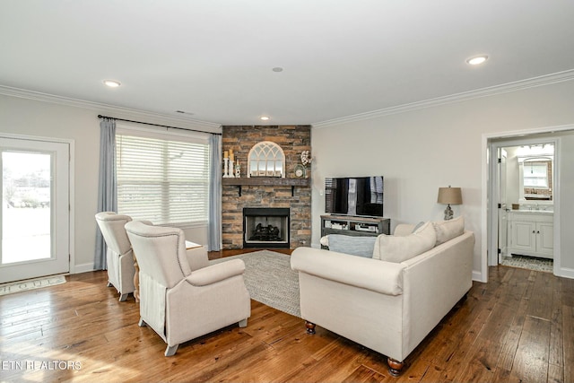 living room featuring ornamental molding, a wealth of natural light, a fireplace, and hardwood / wood-style floors