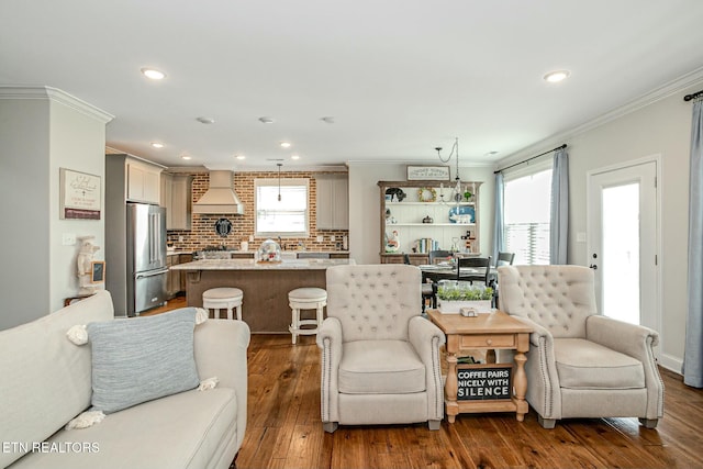 living room featuring a healthy amount of sunlight, dark wood-style floors, crown molding, and recessed lighting