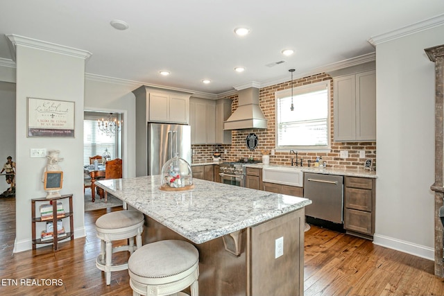 kitchen with crown molding, high quality appliances, custom exhaust hood, and a sink