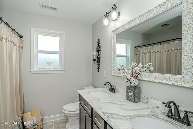 bathroom with toilet, a sink, visible vents, and baseboards