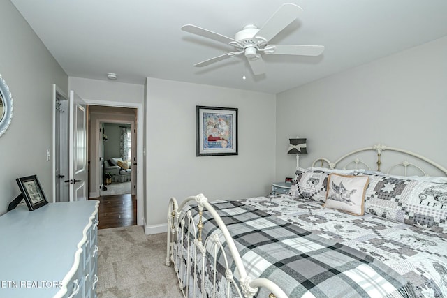 bedroom with light carpet, a ceiling fan, and baseboards