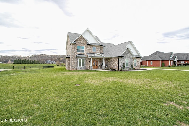 view of front of house featuring brick siding, a shingled roof, fence, and a front yard