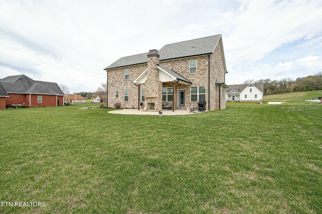 rear view of house with brick siding, a patio, a chimney, and a lawn