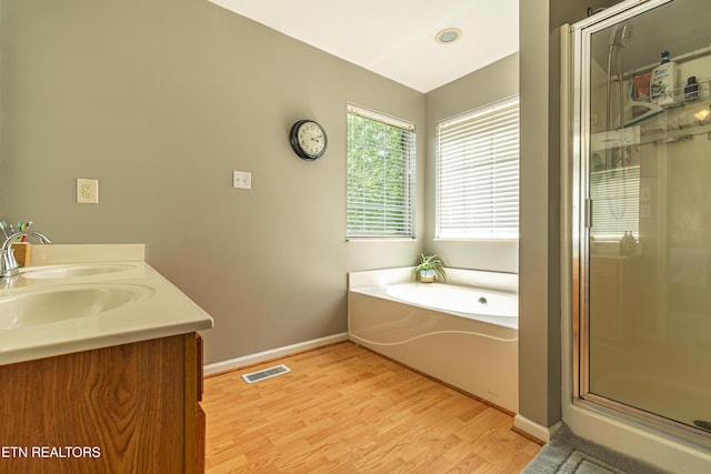 4404 Aylesbury Dr, Knoxville, TN 37918 - bathroom featuring wood finished floors, a sink, a stall shower, a bath, and baseboards
