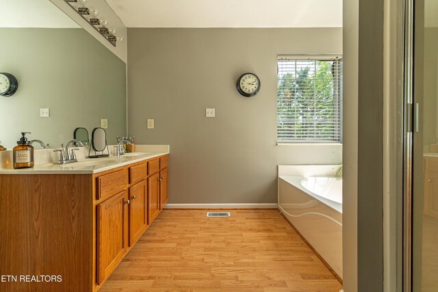 4404 Aylesbury Dr, Knoxville, TN 37918 - full bathroom with wood finished floors, baseboards, a garden tub, and double vanity