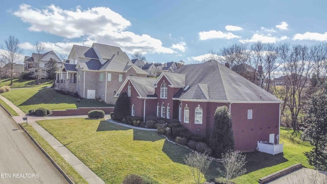 view of front of home featuring a residential view, a front lawn, and brick siding