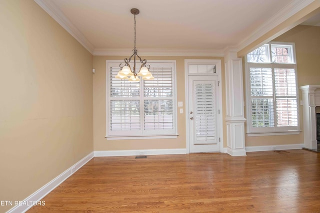 unfurnished dining area featuring ornamental molding, wood finished floors, and baseboards