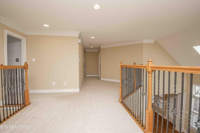 corridor with carpet floors, baseboards, ornamental molding, and an upstairs landing