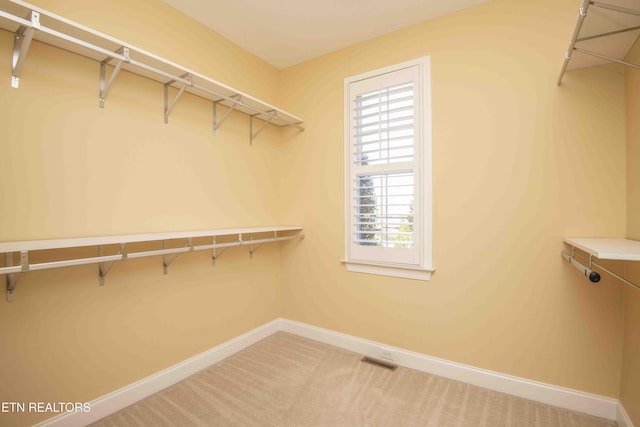 walk in closet with light carpet and visible vents