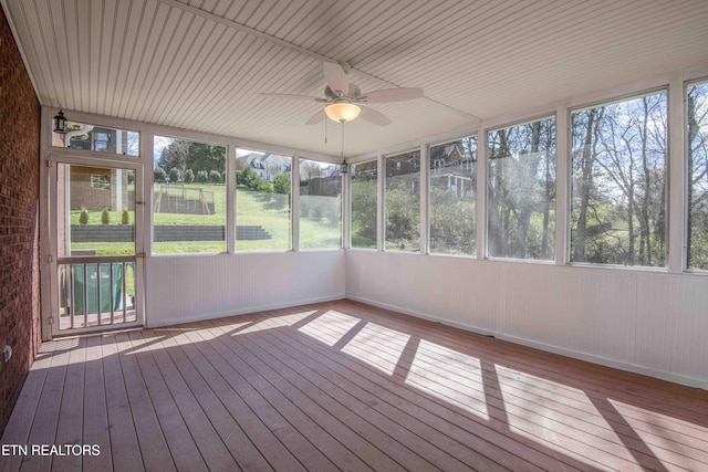 unfurnished sunroom featuring a ceiling fan