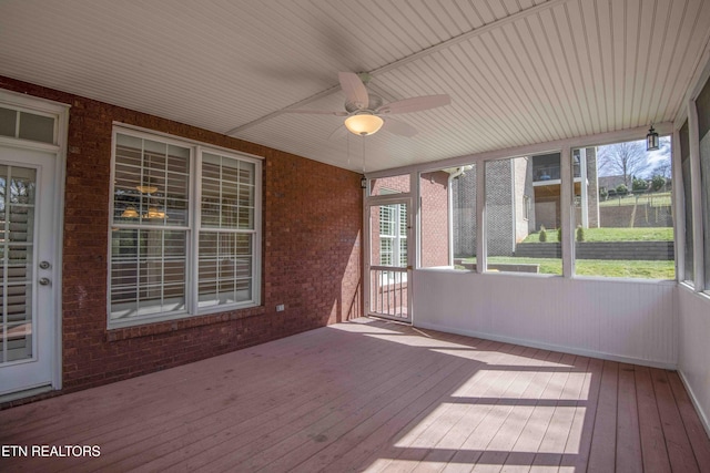 unfurnished sunroom featuring a ceiling fan