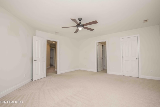 spare room featuring light carpet, baseboards, visible vents, and ceiling fan