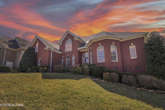 view of front of property with crawl space, brick siding, and a front lawn