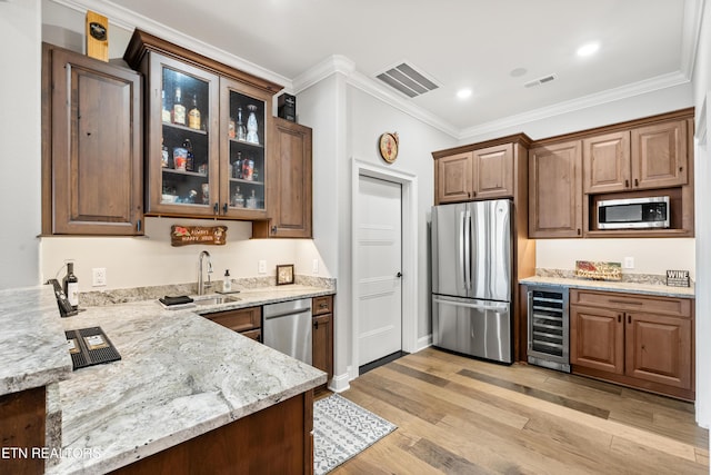 kitchen with appliances with stainless steel finishes, wine cooler, visible vents, and a sink