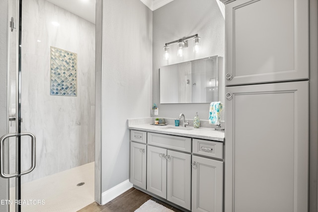 bathroom featuring a stall shower, vanity, and baseboards