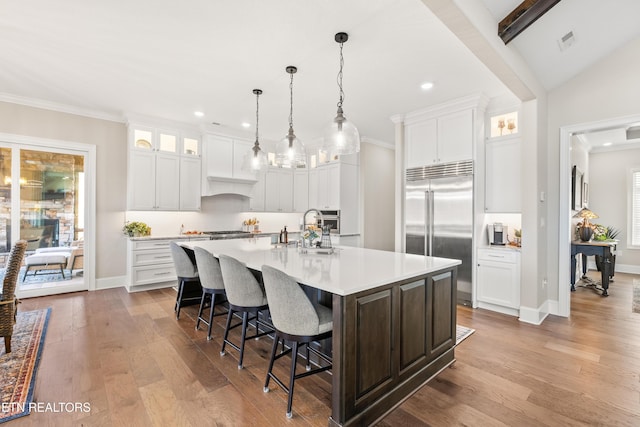 kitchen featuring a spacious island, light countertops, visible vents, appliances with stainless steel finishes, and wood finished floors