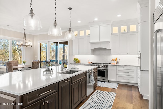 kitchen with high end appliances, light countertops, and a sink