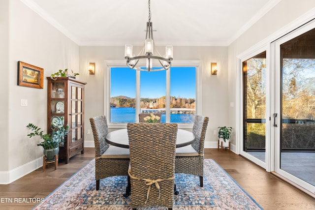 dining area with ornamental molding, dark wood finished floors, a wealth of natural light, and an inviting chandelier