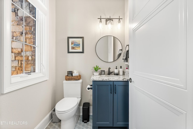 bathroom featuring toilet, baseboards, and vanity