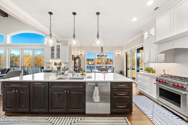 kitchen featuring stainless steel appliances, white cabinets, light countertops, and a sink