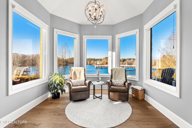 sunroom / solarium with a chandelier and a water view