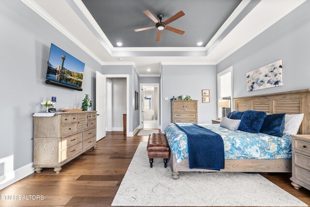 bedroom with baseboards, a raised ceiling, wood finished floors, crown molding, and recessed lighting