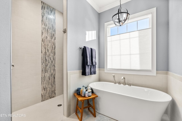 full bathroom with a soaking tub, a wainscoted wall, walk in shower, crown molding, and tile walls