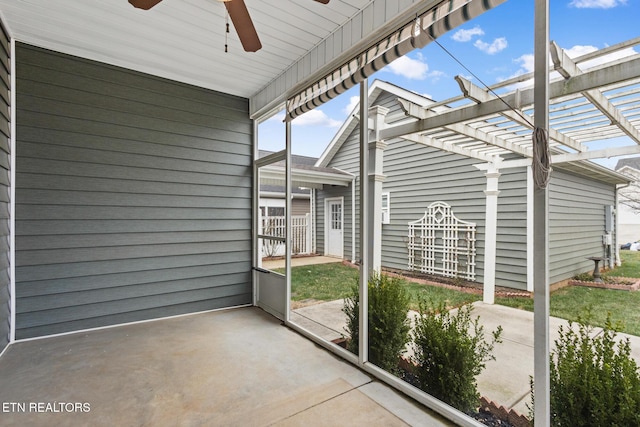 unfurnished sunroom featuring a ceiling fan