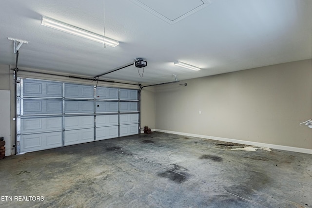 garage featuring a garage door opener and baseboards