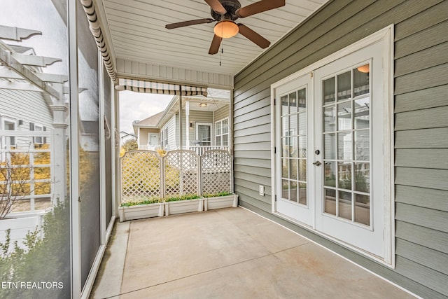 unfurnished sunroom with ceiling fan