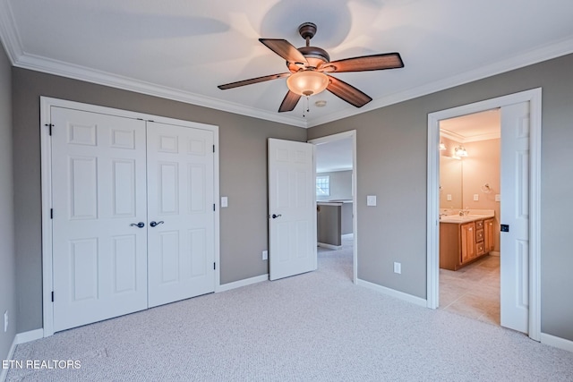 unfurnished bedroom featuring light carpet, a ceiling fan, baseboards, ornamental molding, and a closet