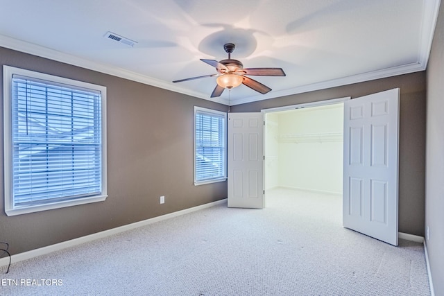 unfurnished bedroom featuring carpet, baseboards, visible vents, and crown molding