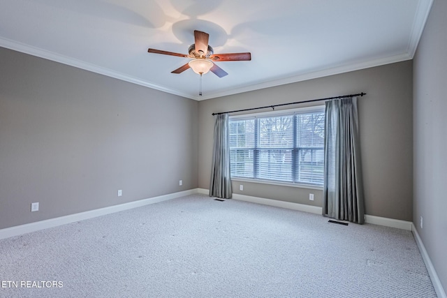 carpeted spare room with baseboards, visible vents, ornamental molding, and ceiling fan