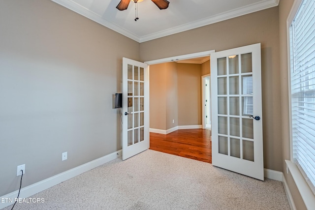 carpeted empty room featuring a ceiling fan, french doors, crown molding, and baseboards