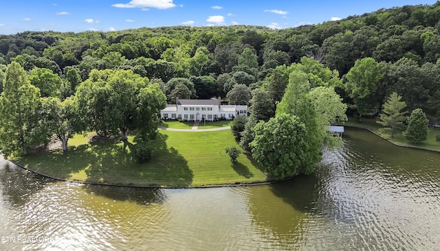 birds eye view of property featuring a forest view and a water view