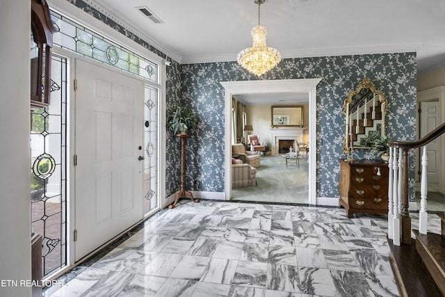 foyer with wallpapered walls, crown molding, a fireplace, and baseboards