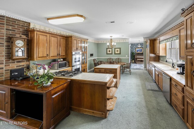 kitchen with tile countertops, brown cabinetry, visible vents, a sink, and appliances with stainless steel finishes