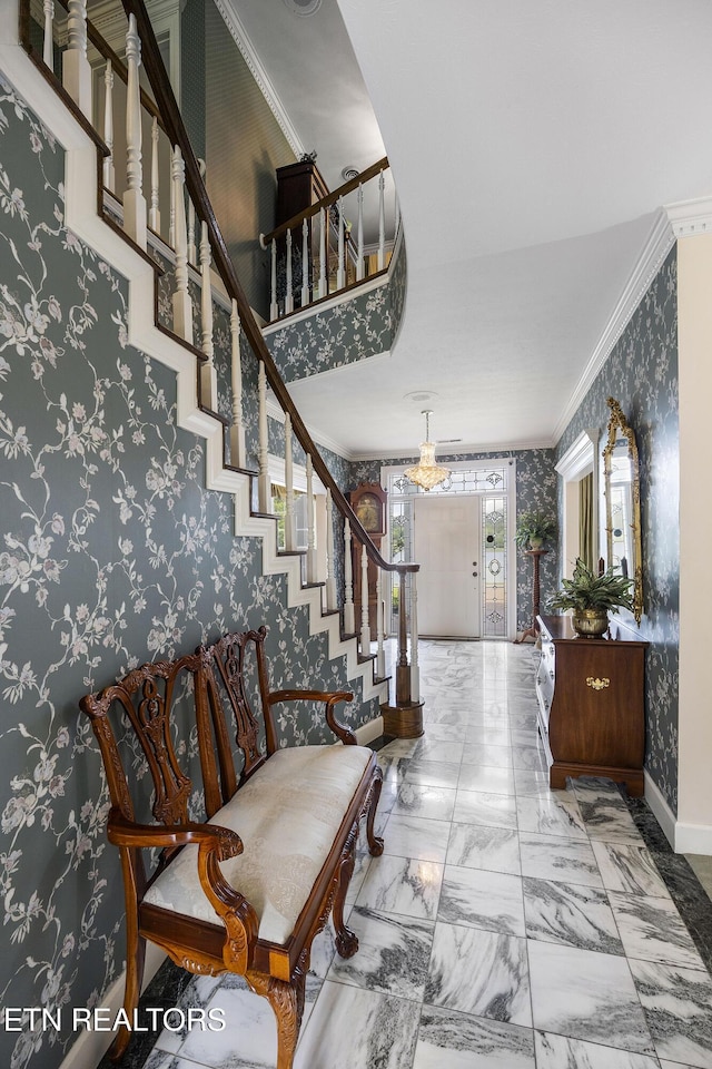 entrance foyer with marble finish floor, wallpapered walls, crown molding, and baseboards