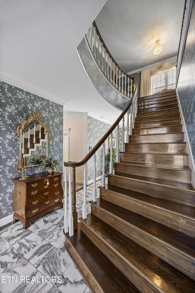 staircase with marble finish floor, wallpapered walls, crown molding, and baseboards