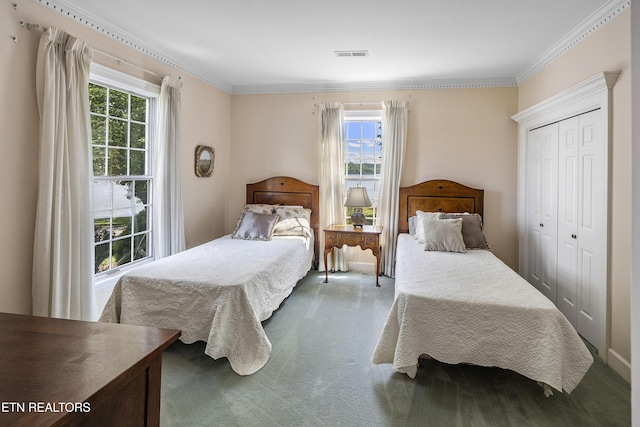 bedroom featuring a closet, visible vents, ornamental molding, and carpet floors