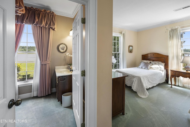 carpeted bedroom with visible vents, multiple windows, and wallpapered walls